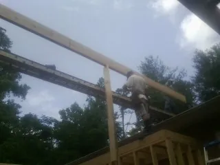 Carpenter setting a ridge beam over a new addition frame — Ice Dam Removal by Roofing Brothers in Crown Point